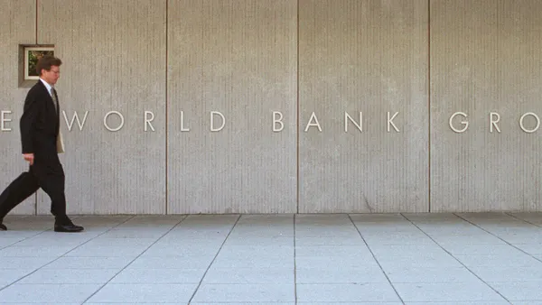 A man passes by the sign of the World Bank Group.