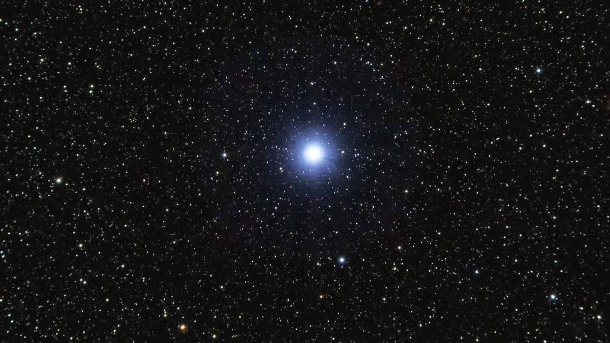 The star Vega shines brightly in the night sky, surrounded by other stars.