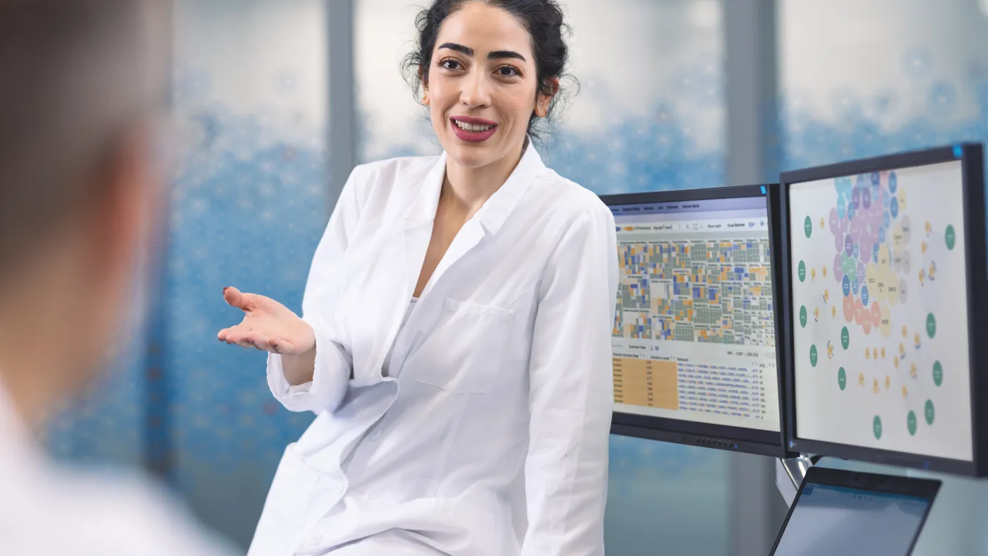 Woman doctor in white lab coat speaking with someone