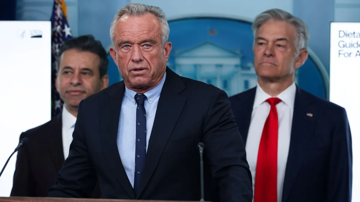 Robert F. Kennedy Jr. stands at a podium that has "The White House" written on it.