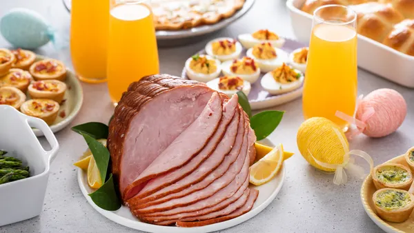 Ham, deviled eggs and drinks on a table.