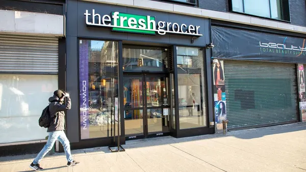 A grocery store with a sign reading "The Fresh Grocer" above the entrance