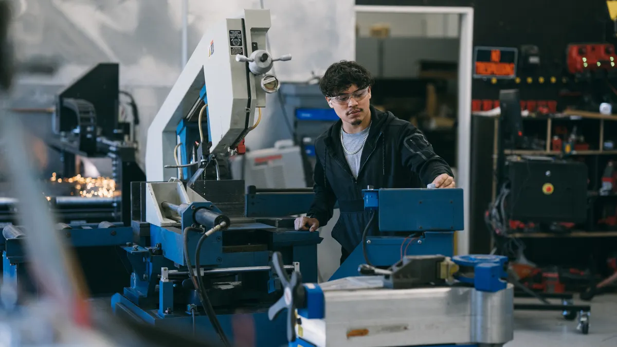 Engineer operating metal engraver in factory