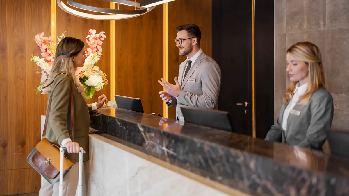 A woman checks into a hotel at the front desk.