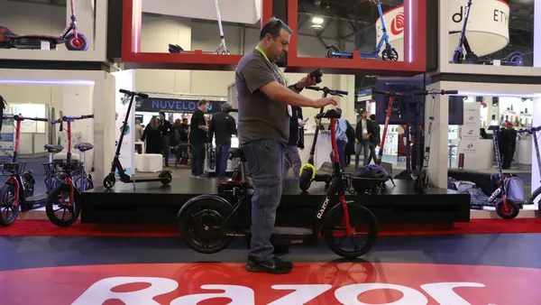 A man inspects an electric scooter