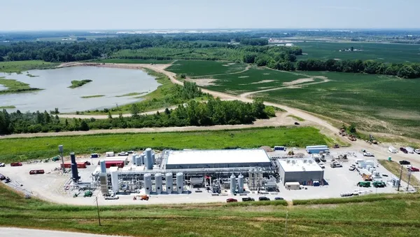 Aerial view of an industrial facility near green engineered hills