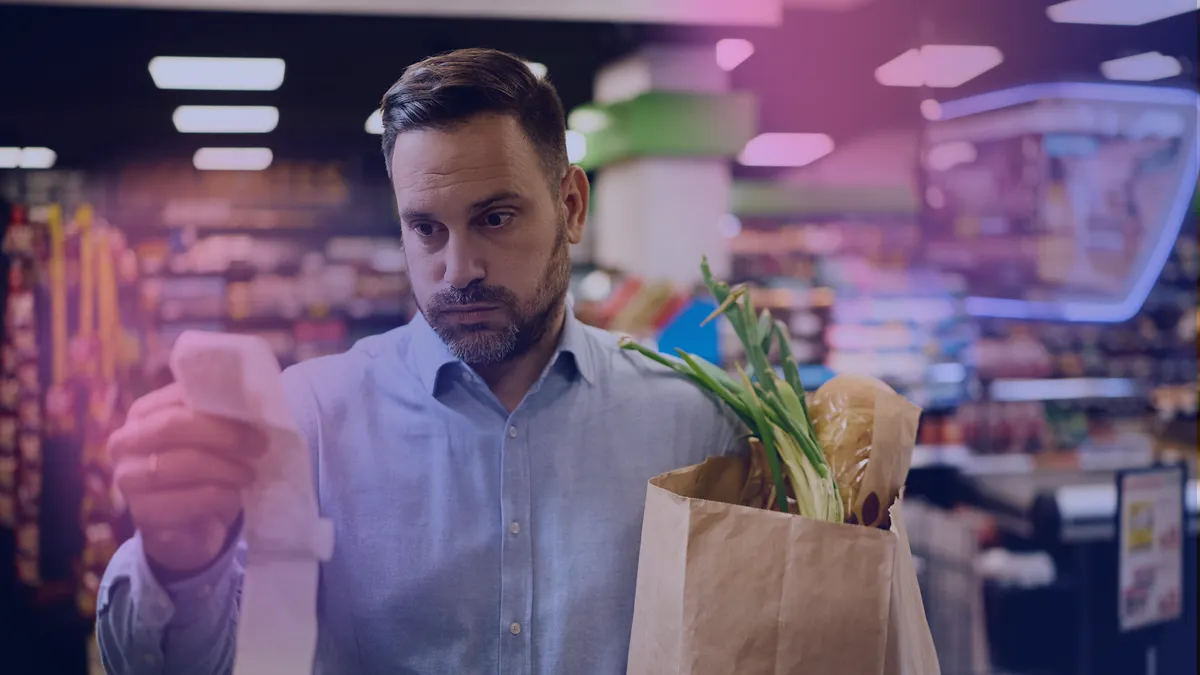 Man looking frustrated at long receipt