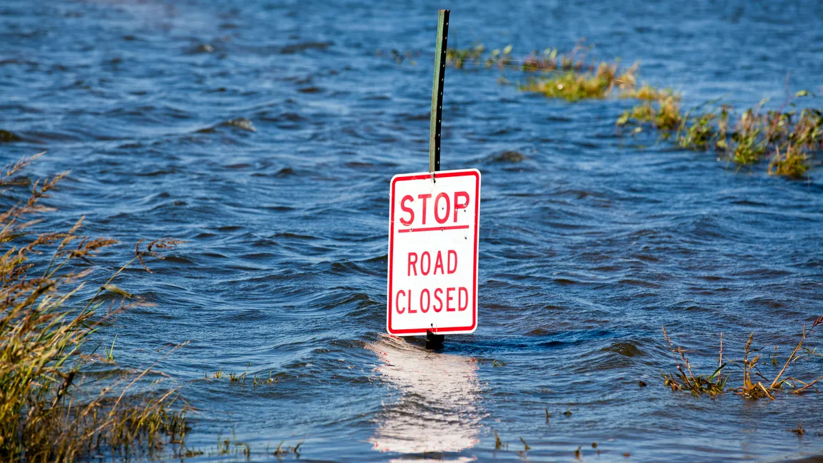 A street sign above floodwaters