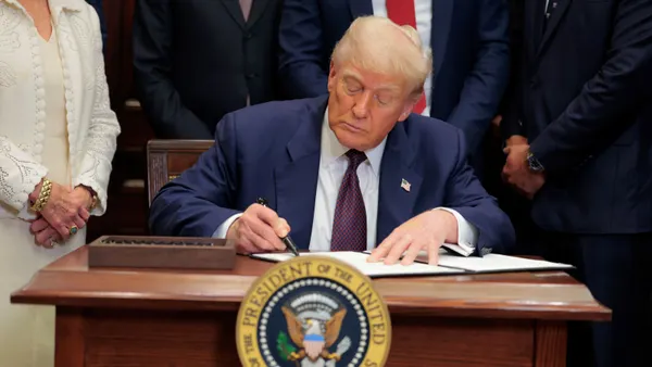 President Donald Trump signs an executive order at the White House on July 31, 2025.