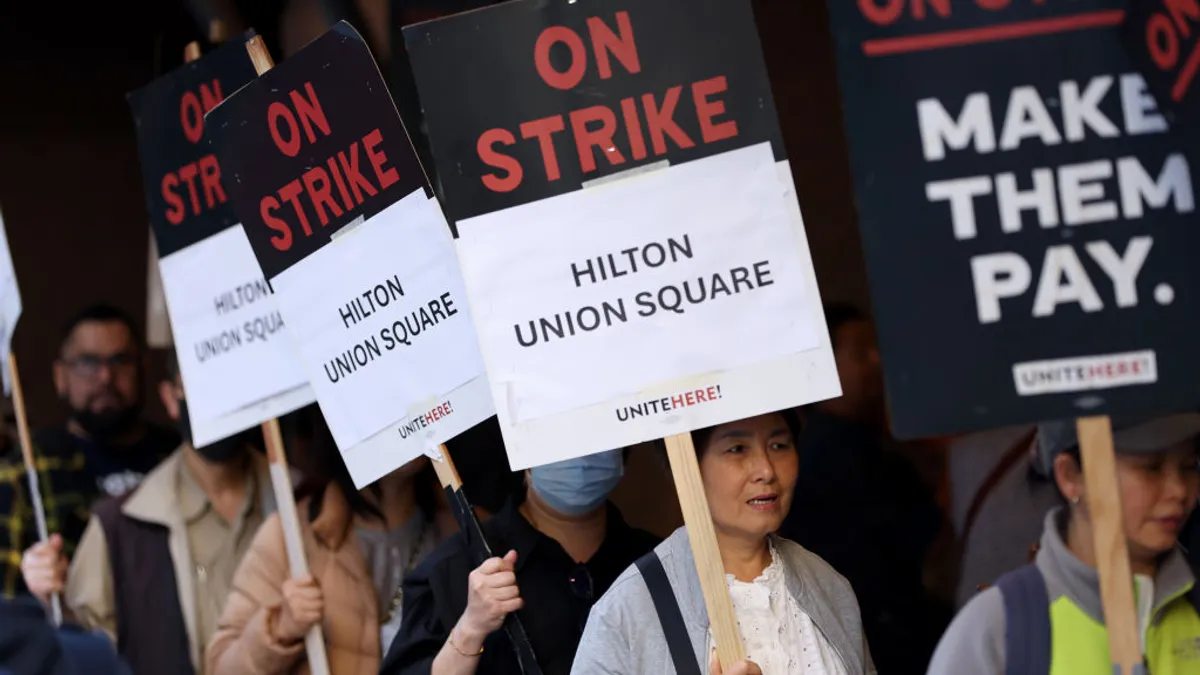 Workers hold signs reading "on strike."