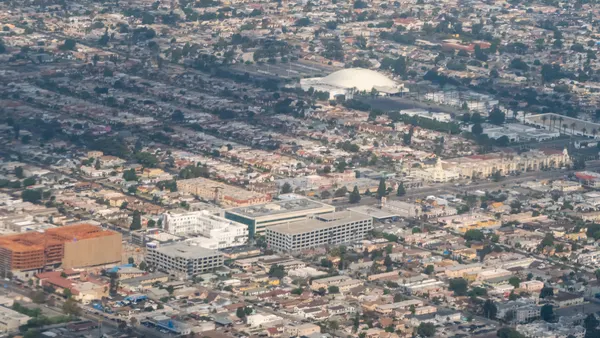 A sprawling urban landscape featuring densely packed residential and commercial buildings, streets, and intersections