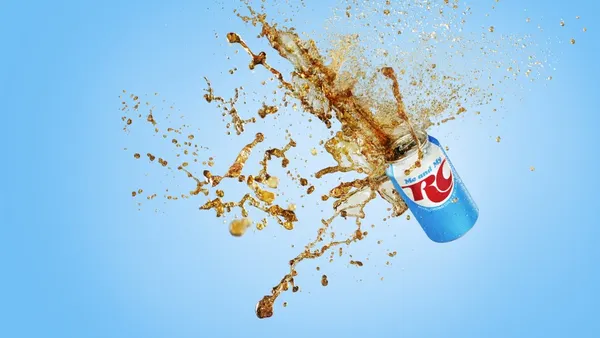A RC Cola is pictured in the air, spilling soda.