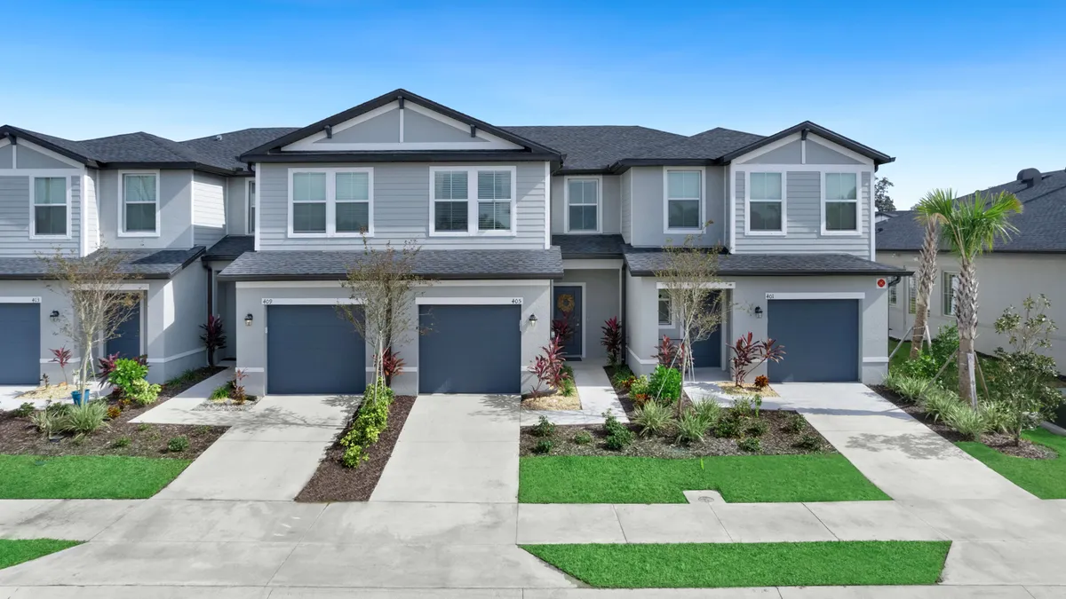 Grey two-story homes with driveways in the foreground.