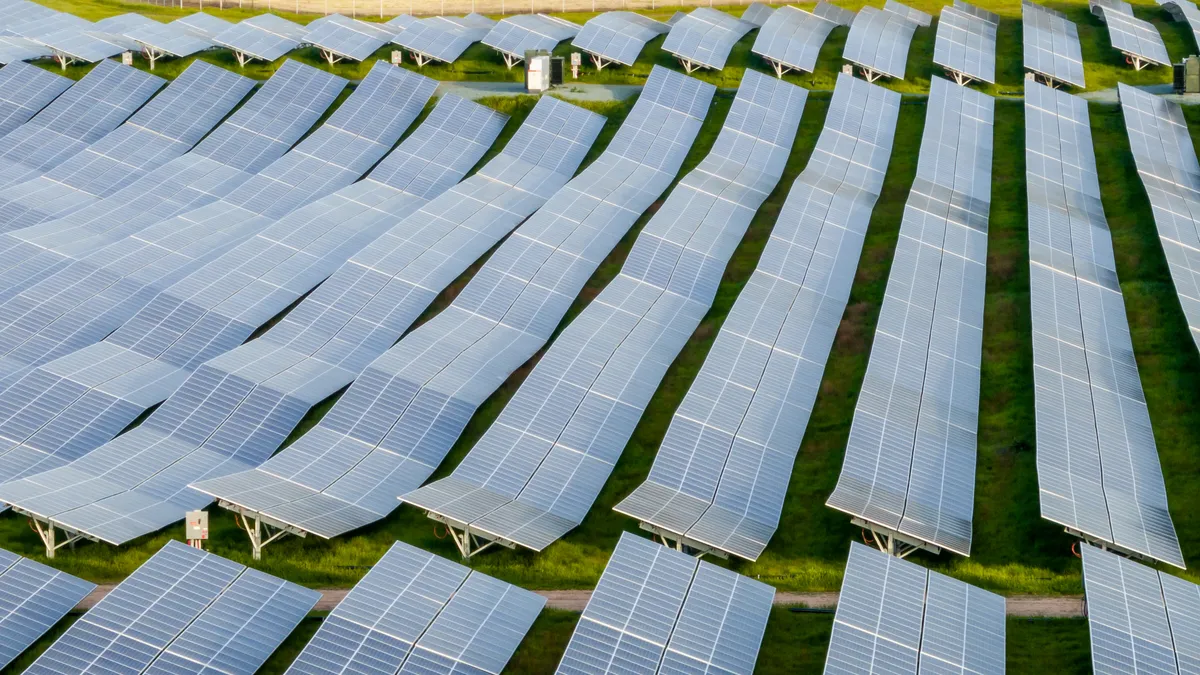 Rows of undulating solar panels in a field.