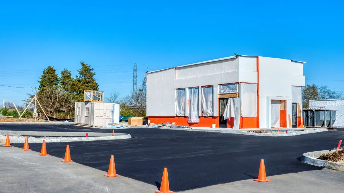 A newly paved parking lot at a under construction fast food restaurant.