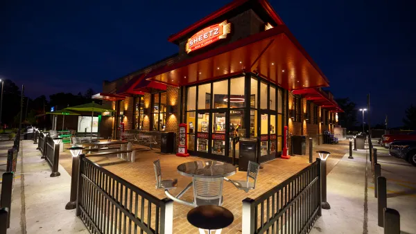 A photo of the exterior of a convenience store at night. A sign on the wall says Sheetz, fresh food made to order.