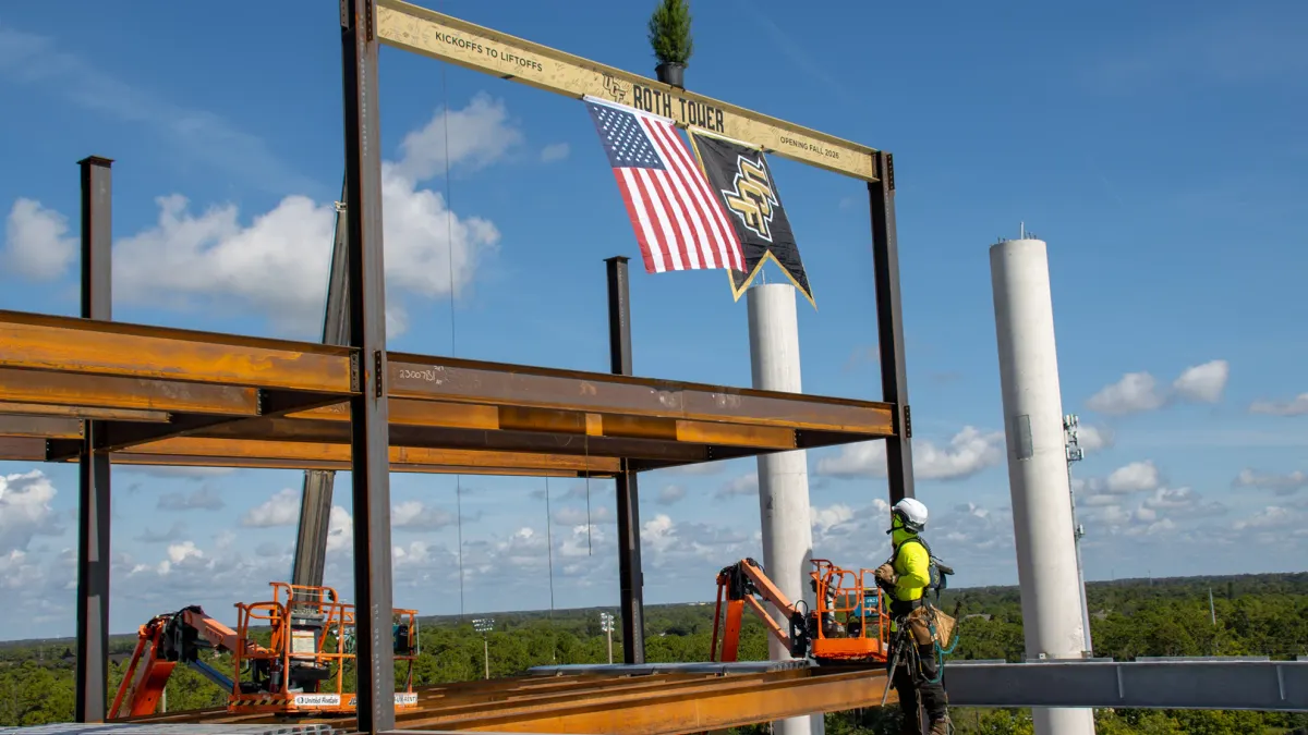 A construction worker on top of a tall construction project.
