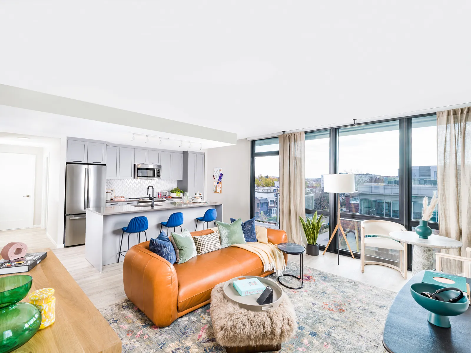 a living room and kitchen with a blue couch.