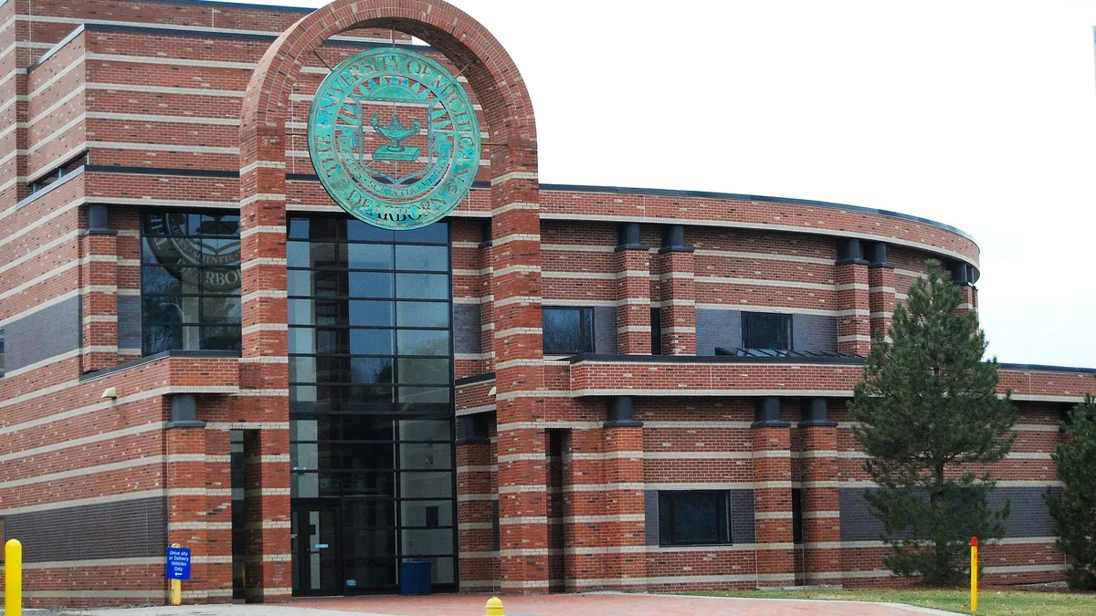 Brick building with green round sign out front.