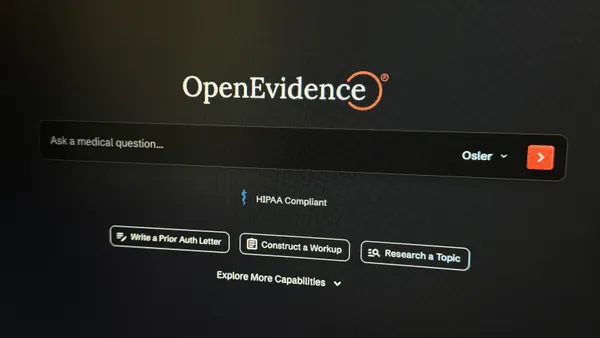A close-up photo of a computer screen displaying the OpenEvidence homepage in dark mode. The "OpenEvidence" logo is at the top. Below is a search bar with the placeholder text, "Ask a medical question..." Under the search bar, it says "HIPAA Compliant." Three buttons below offer options to "Write a Prior Auth Letter," "Construct a Workup," and "Research a Topic."