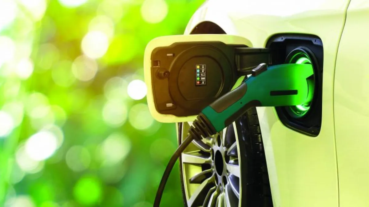 A green charger connected to a yellow EV.