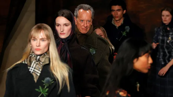 Runway models, including actor Richard E. Grant, walk on a  runway wearing clothing from Burberry.