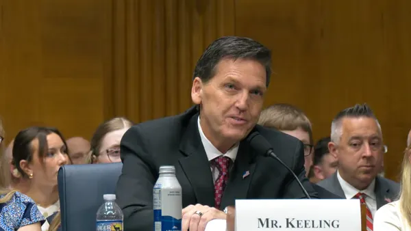 A screenshot of David Keeling speaking at a podium