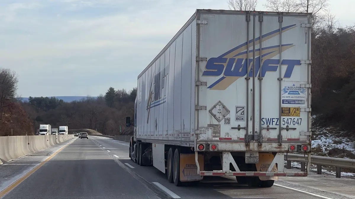 A Swift tractor-trailer on the Pennsylvania Turnpike with oncoming traffic on the other side of the median.