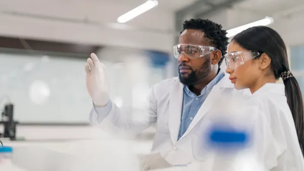 Scientists working in Laboratory for visual analyze the sample in petri dish.