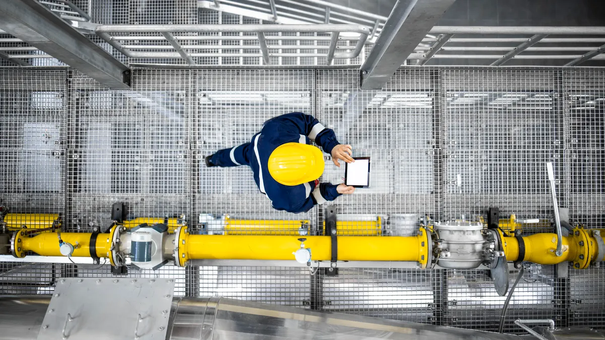 A worker walking through a factory.