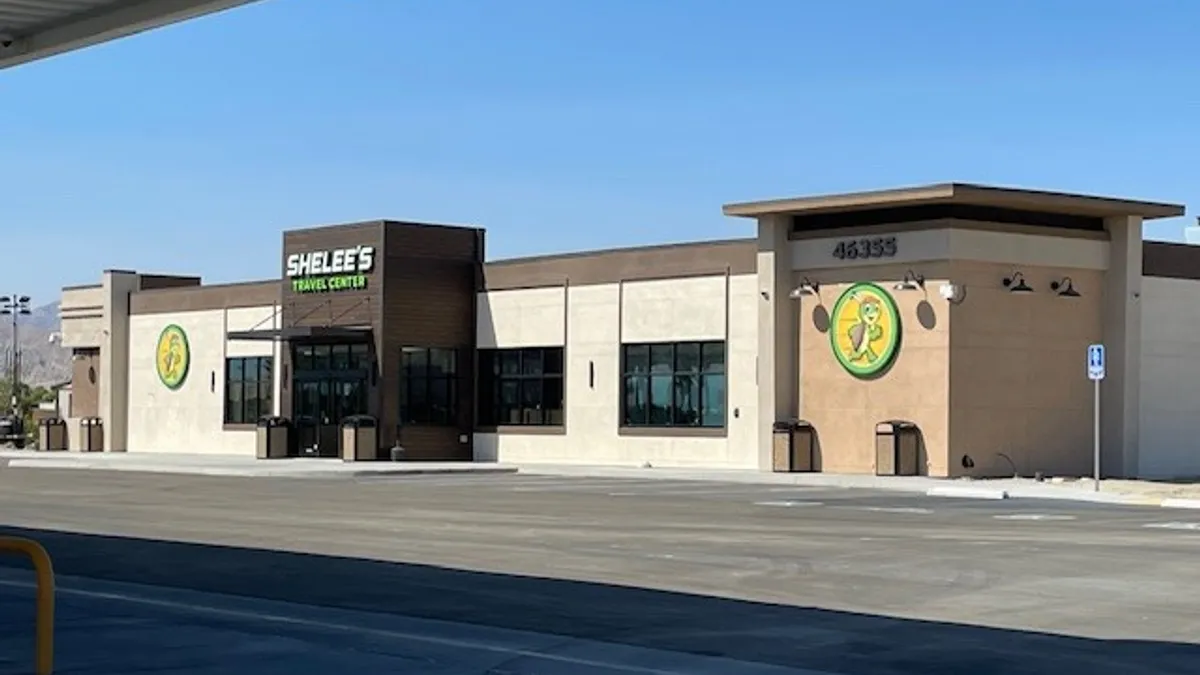 A photo of the exterior of a truck stop. A sign on the store says "Shelee's."