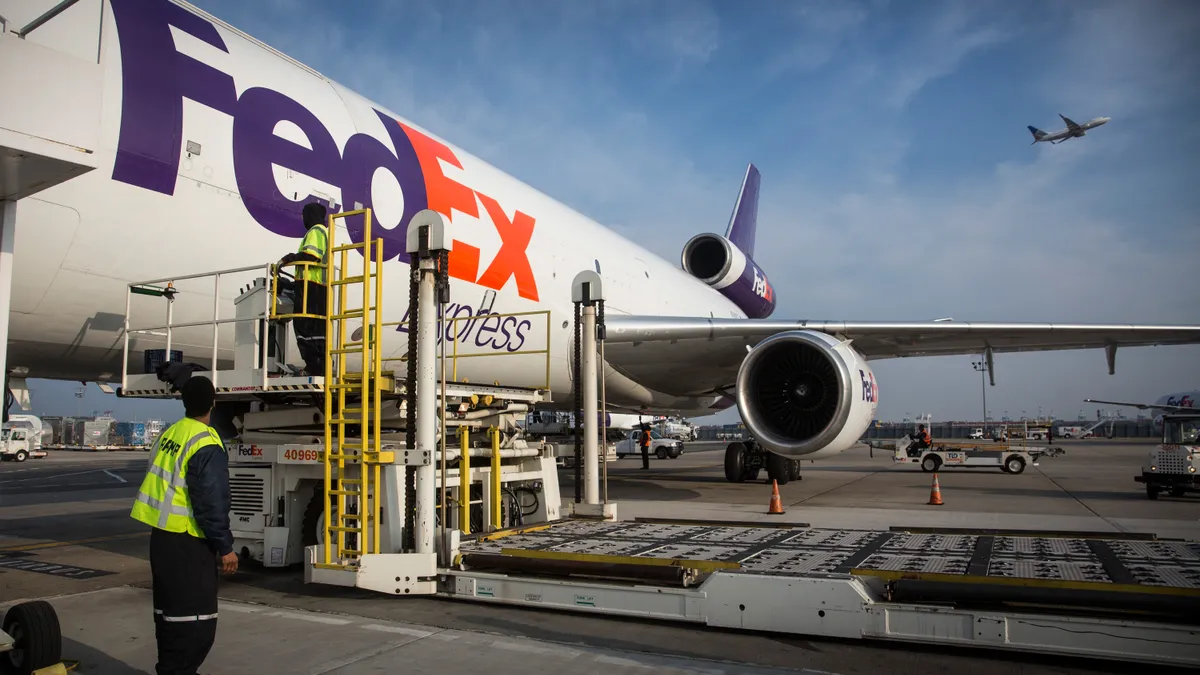 Workers prepare to offload an incoming FedEx plane at a FedEx global hub on December 16, 2014 in Newark, New Jersey.