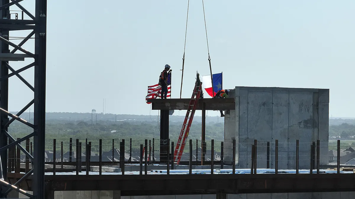 Workers help place the highest steel beam on Palo Alto Hospital in San Antonio, Texas.