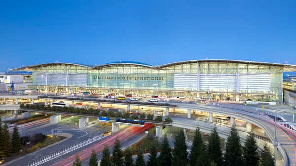 A landscape shot shows the main terminal for San Francisco International airport illuminated at dusk.