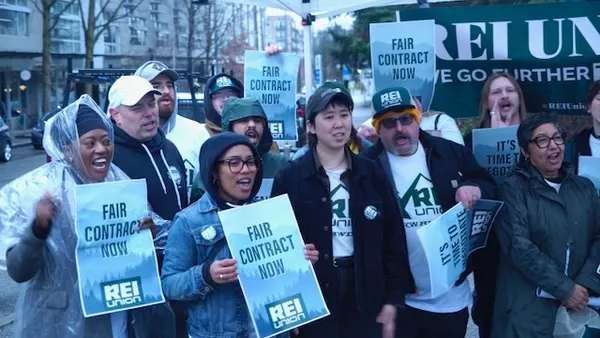 A group of people holding signs that say "Fair contract now."