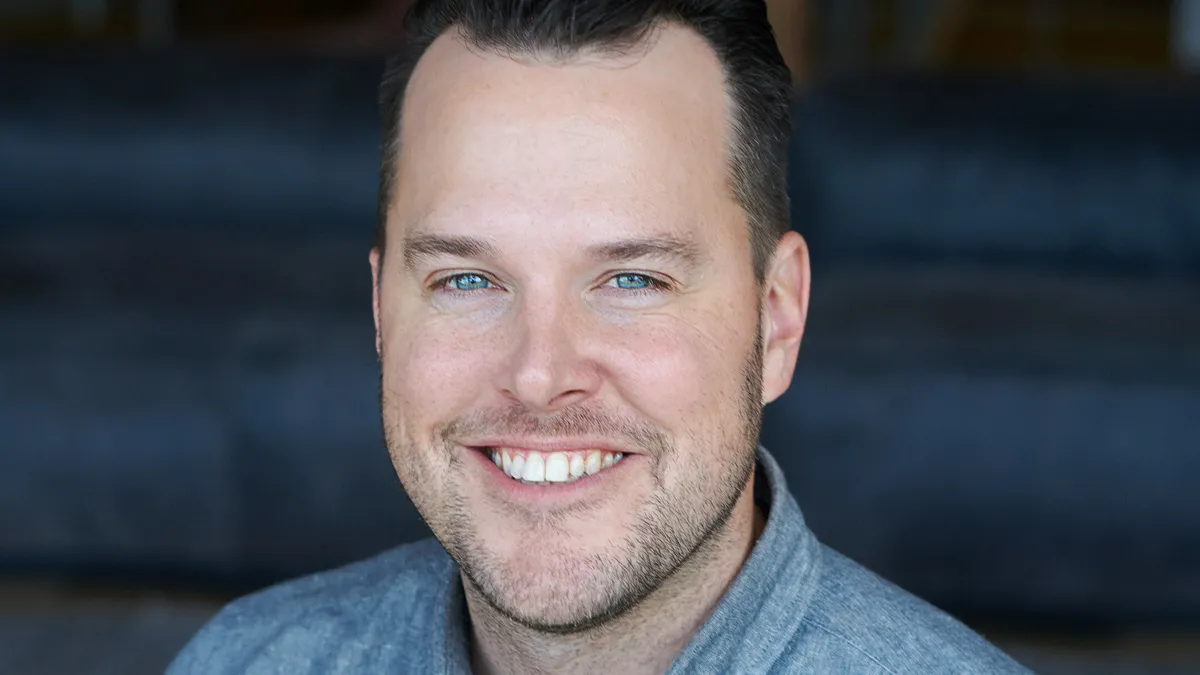 A portrait photograph of Jesse Johnson, Chili's VP of Marketing. Johnson is smiling and wearing a blue shirt.