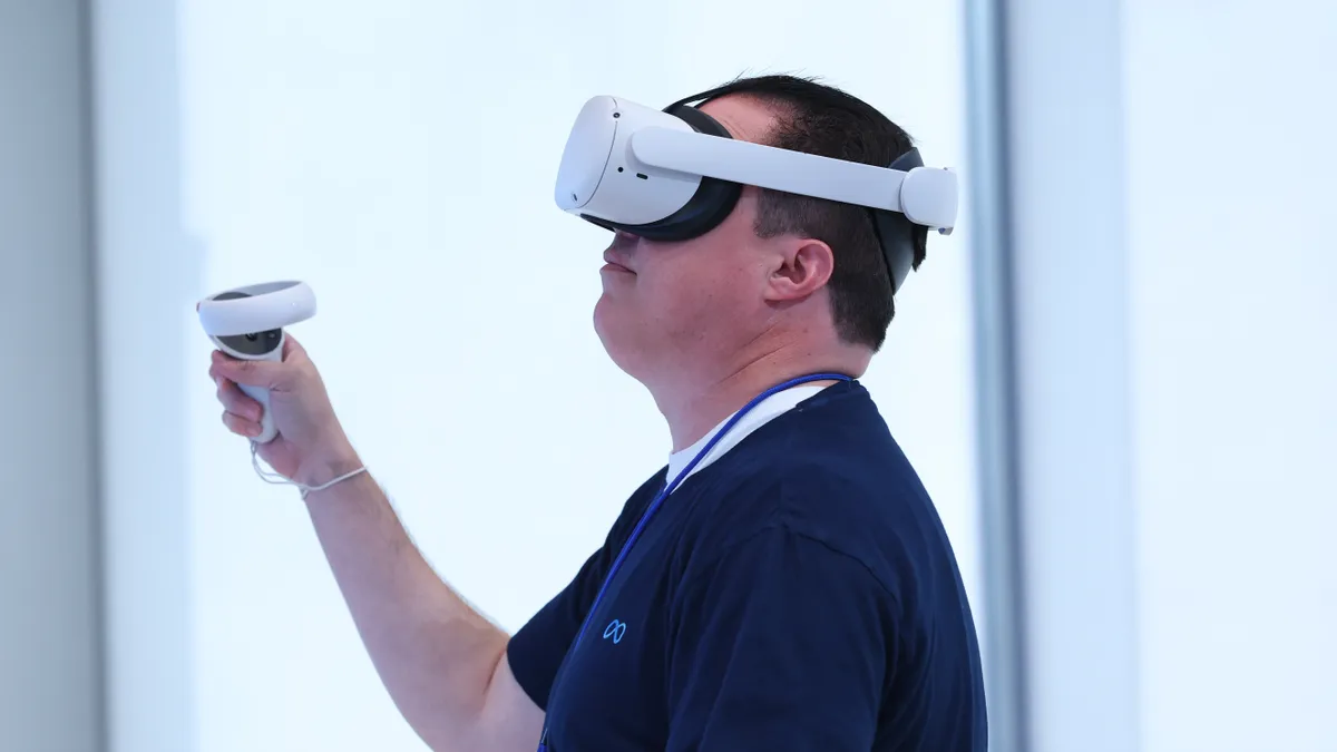 Meta employee Dennis Hampton demonstrates a video game that is played using the Oculus Quest 2 virtual reality headset at the new Meta Store on May 04, 2022 in Burlingame, California.