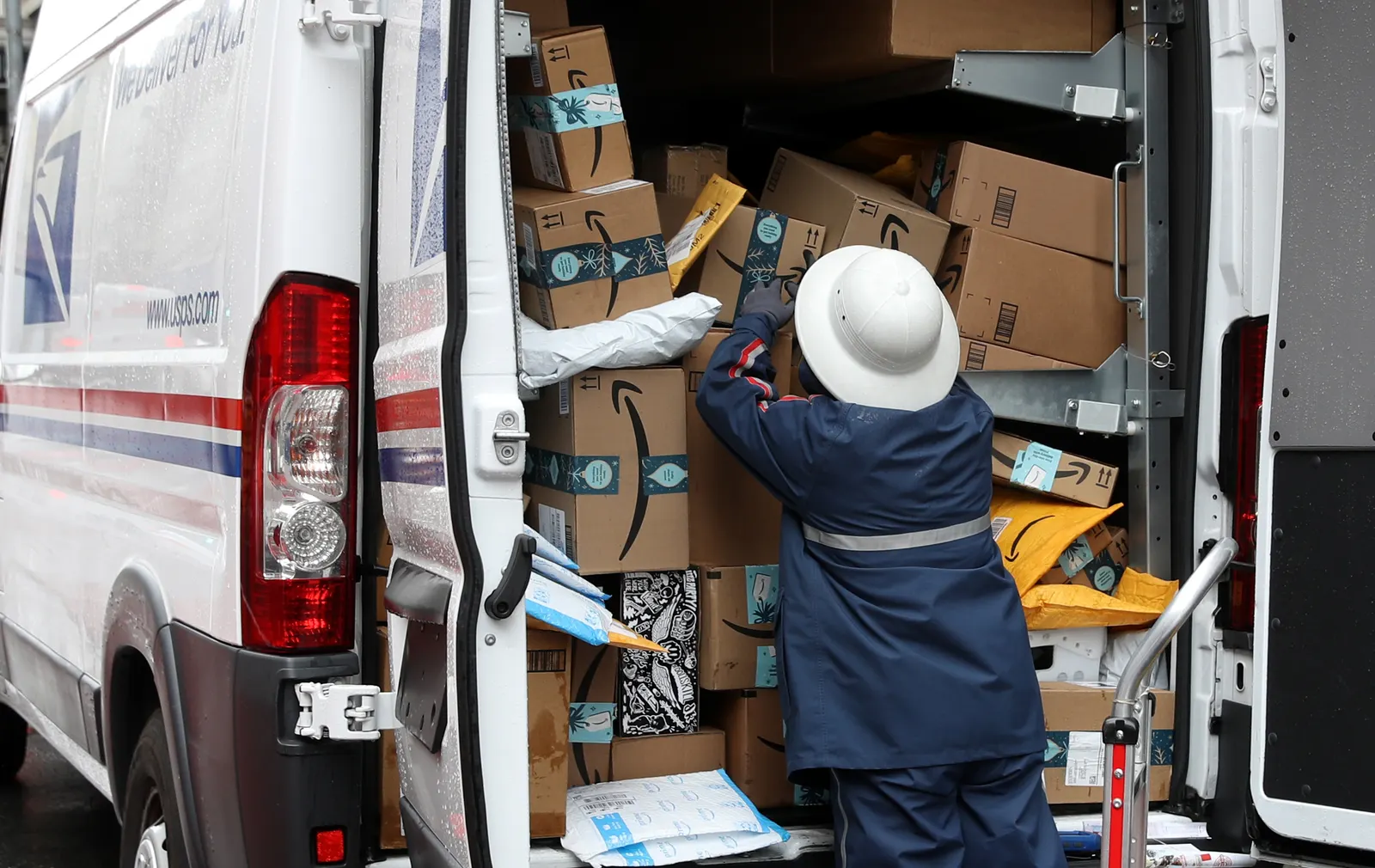 A U.S. Postal Service worker unpacks packages from a truck on December 02, 2019 in San Francisco, California.