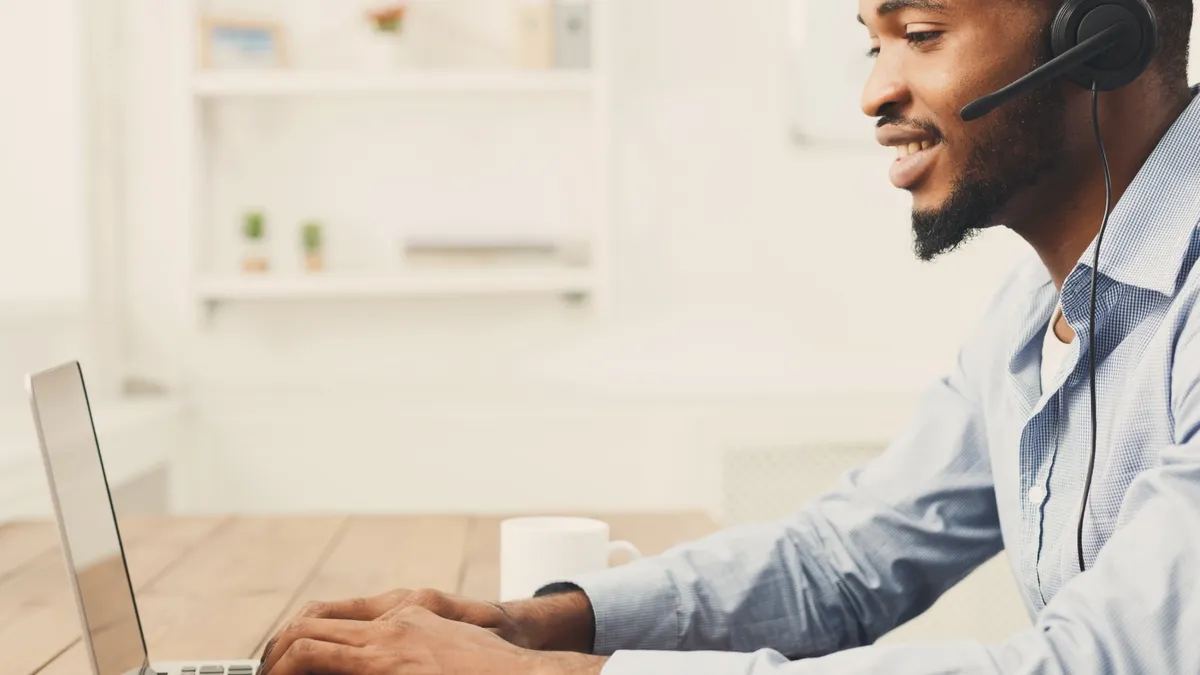 Person looking at laptop with call headset on