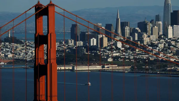 An aerial view of the Golden Gate Bridge in front of the San Francisco skyline.