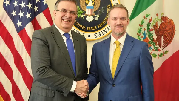 U.S. President Donald Trump and Japanese Prime Minister Sanae Takaichi hold up signed documents.