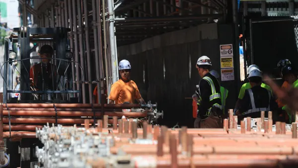 Construction crews around scaffold in the city.