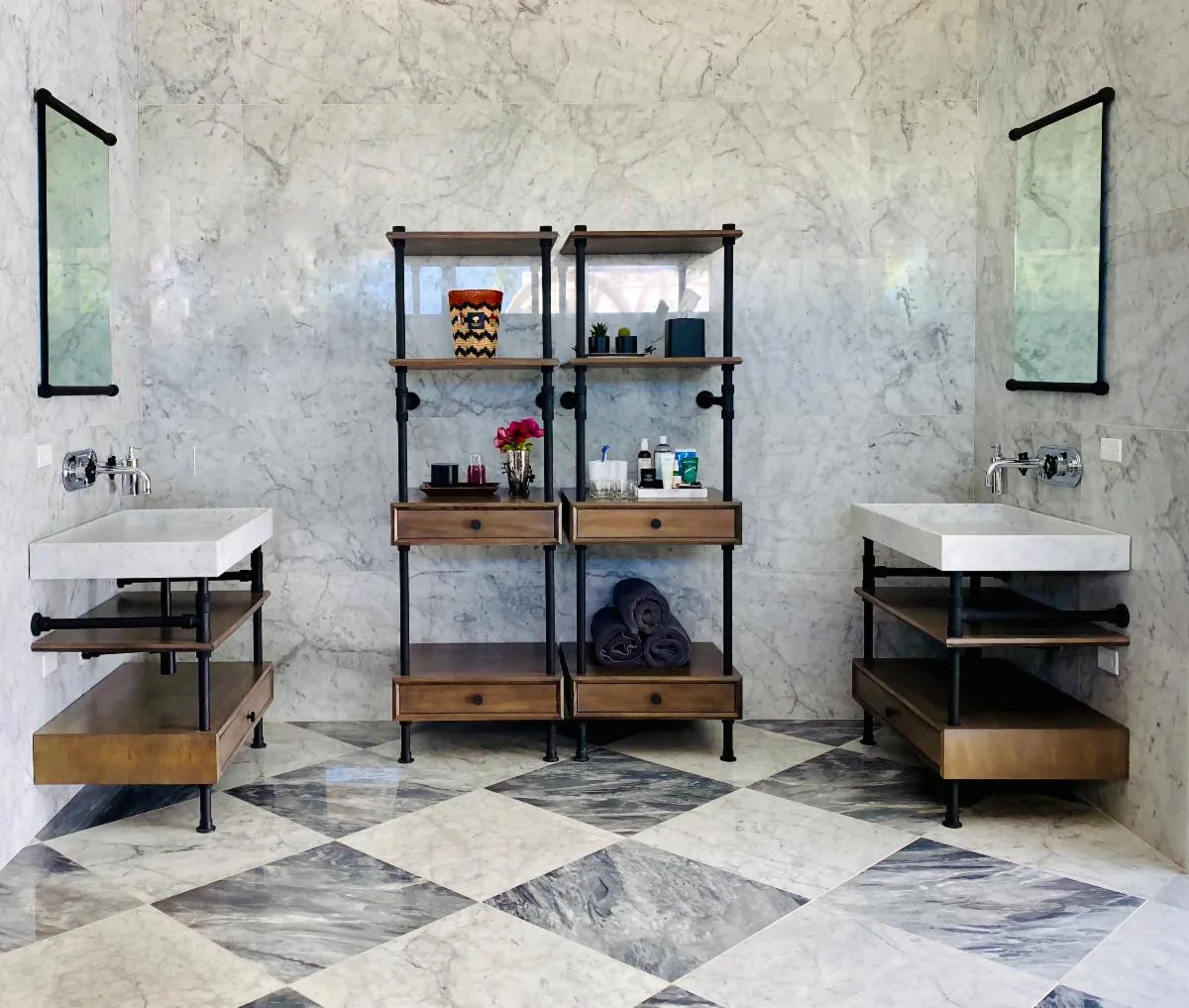 A bathroom with two sinks and wood storage shelves.