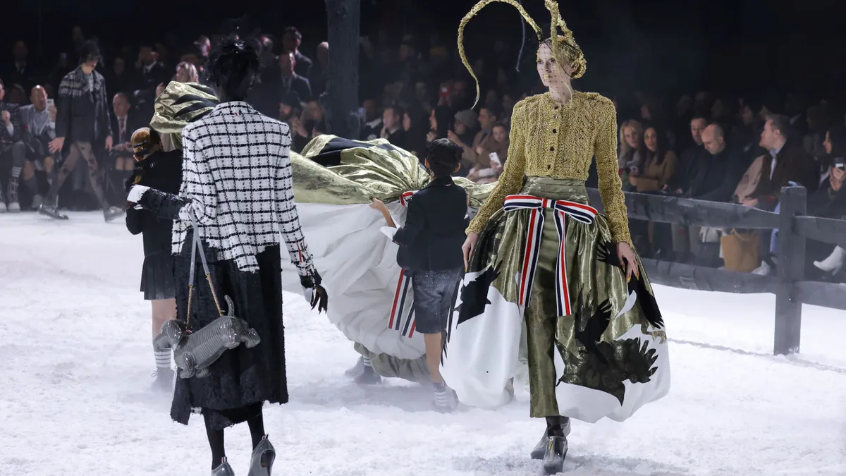 Models walk in a circle on the runway wearing items from Thom Browne.