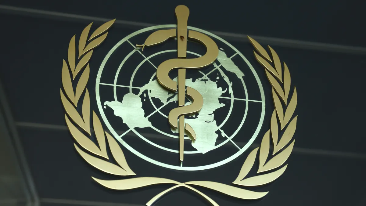 The World Health Organization emblem of a snake symbol for medicine coiling around UN symbol.