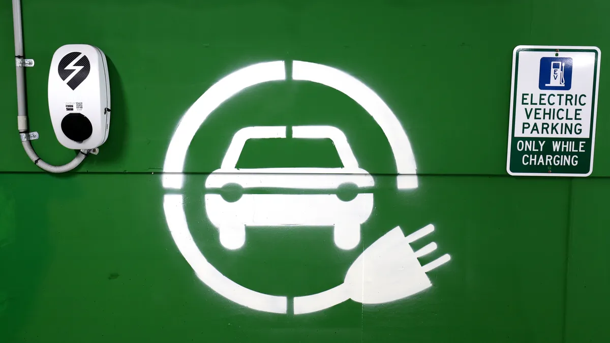 A photo of an electric car charging symbol on a wall.