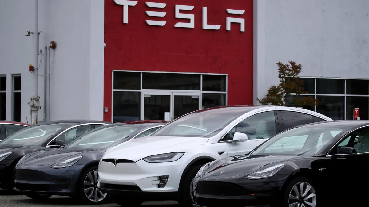 A vehicle for sale sits in front of a showroom