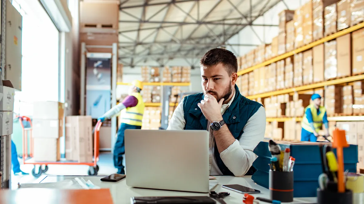 Close up of a warehouse manager using a laptop