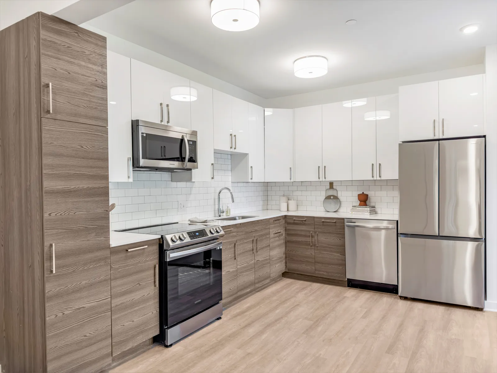 A kitchen with wood flooring and stainless steel appliances.