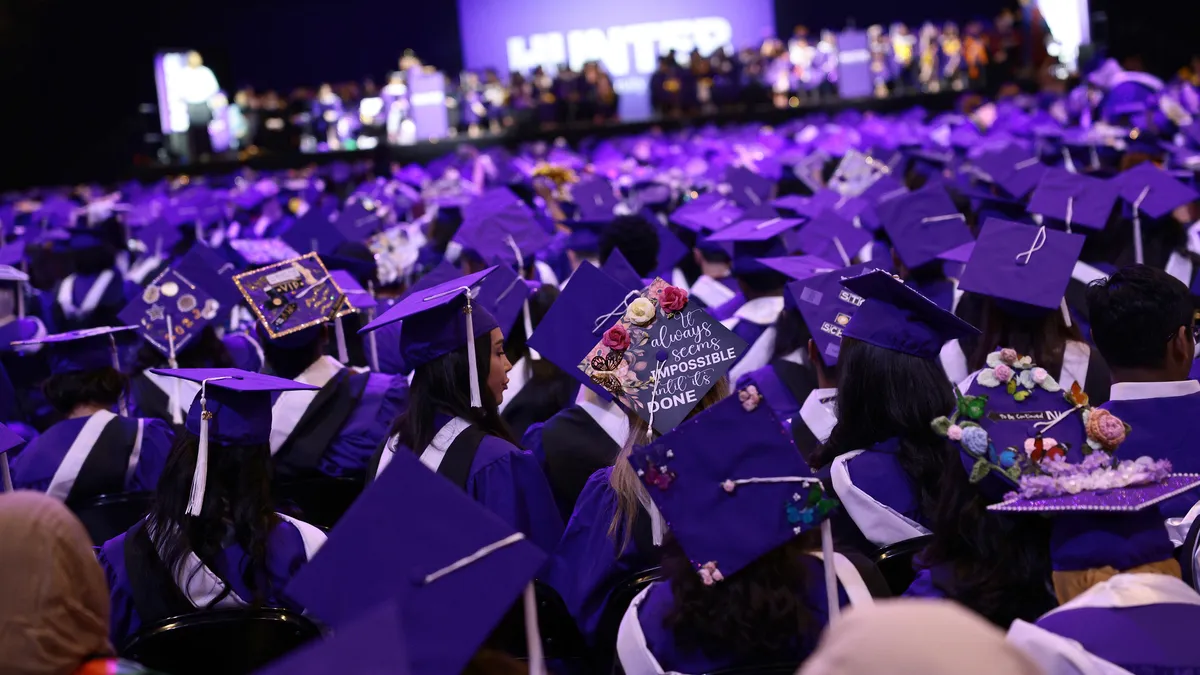 A sea of graduation caps is seen as students listen to a commencement address.